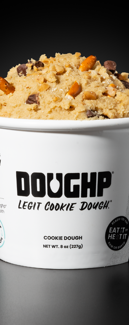 Close shot of Naughty & Nice cookie dough flavor from Doughp displaying pretzels, chocolate chip, and caramel pieces in the dough